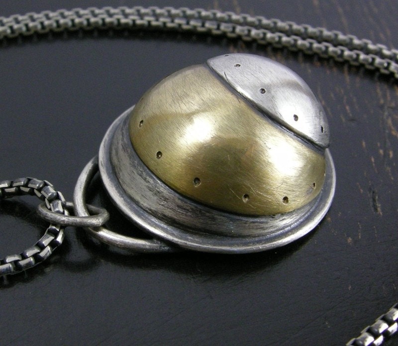 Sterling silver and brass hollow pendant.