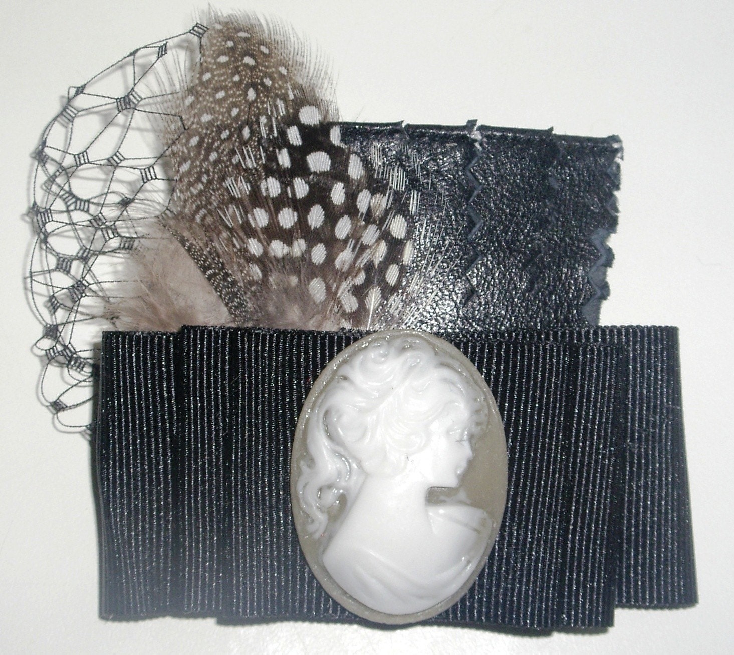 cameo brooch over black with feathers
