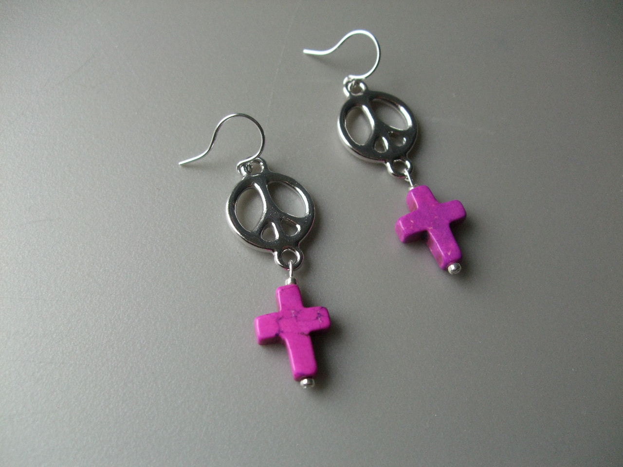 Silver peace sign and purple cross earrings