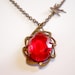 Red Faceted Oval Ruby Glass Stone in Brass Setting with Brass Sparrow Flying High