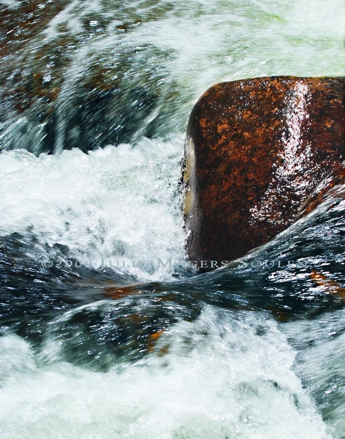 swirling whirlpool with wet boulder in St. Vrain River Rocky Mountain National Park Colorado